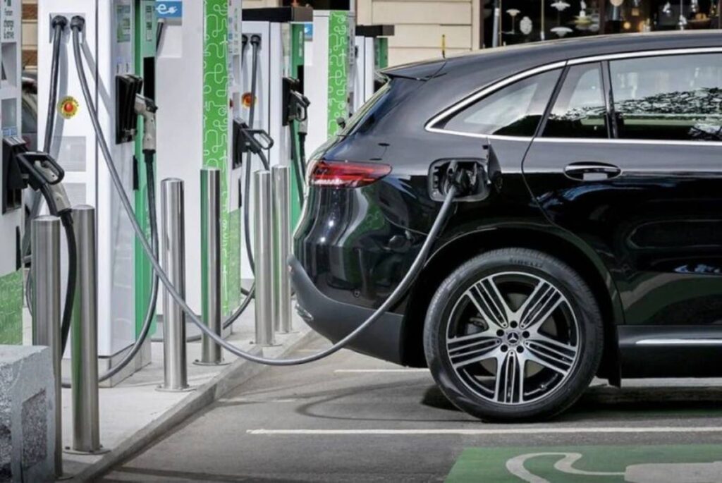 A black SUV is charging at a modern electric vehicle charging.