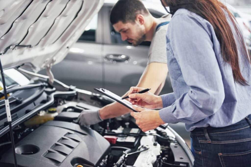 People inspecting car engine