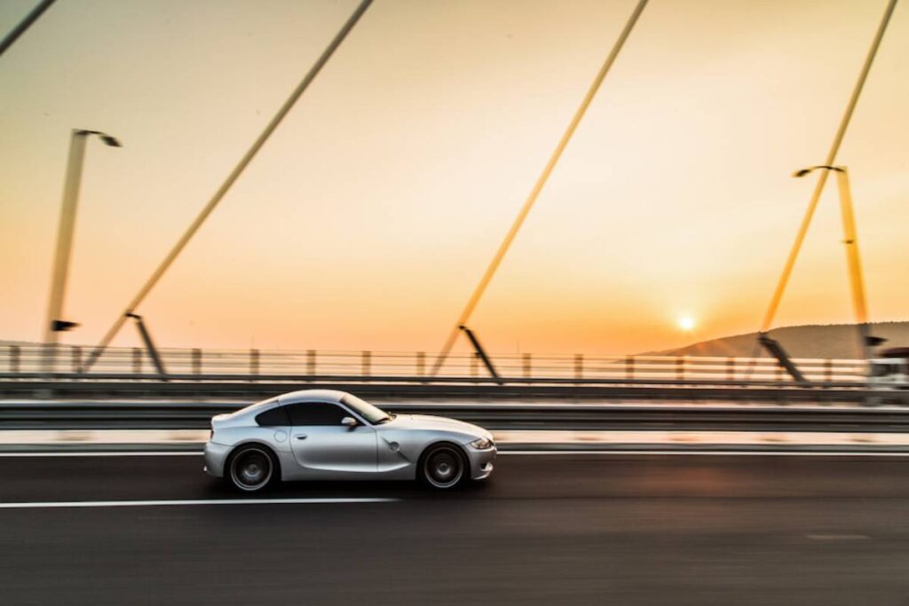 Silver car on bridge at sunset