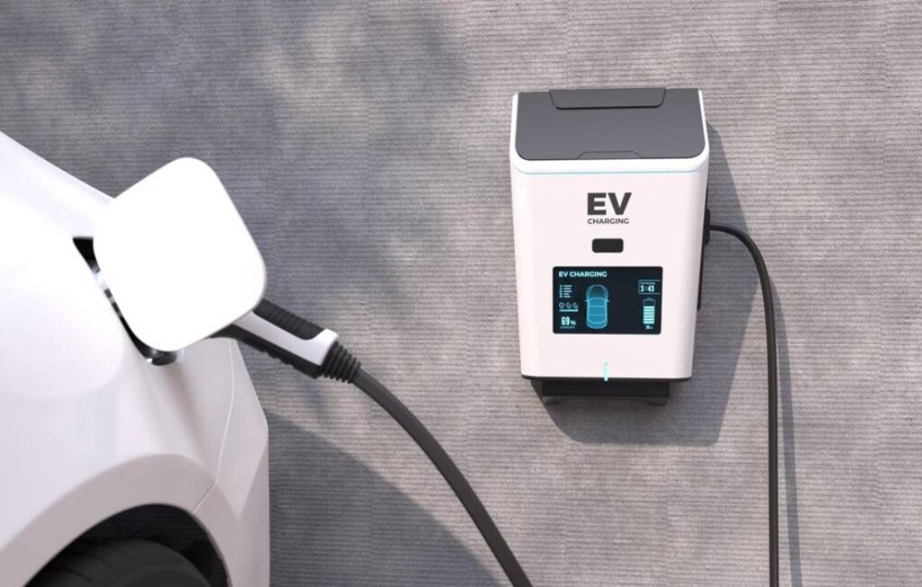 A white electric vehicle is plugged into a modern EV charging station.