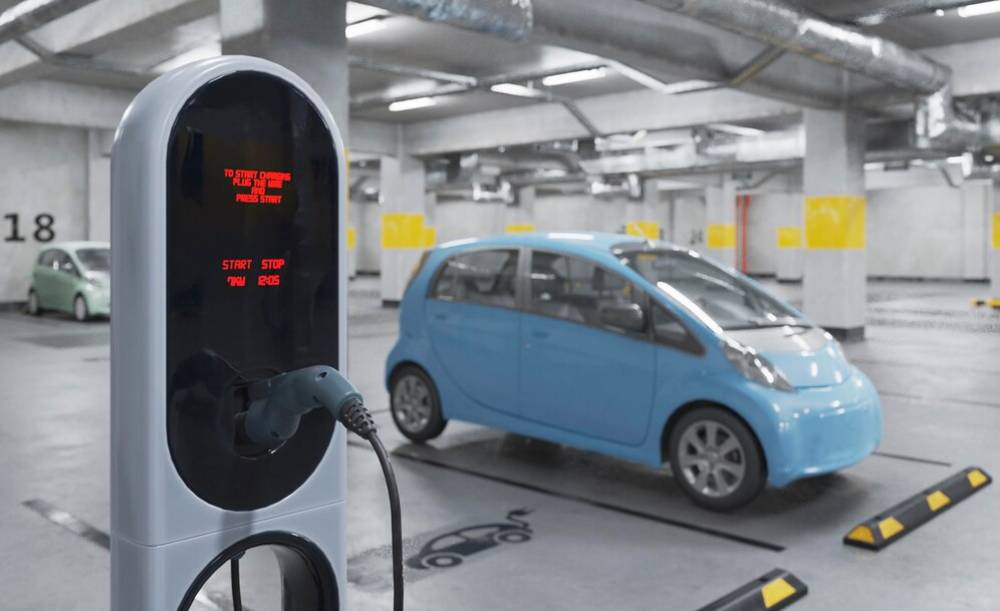  A blue electric car connected to a charging station, indicating it is in the process of charging.