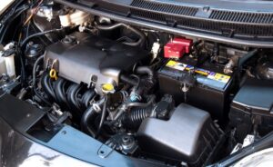 A car engine is visible with the hood open, showcasing the internal components and mechanics of the vehicle.