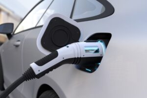 An electric car being charged with a modern charging cable displaying a "FULL" indicator.